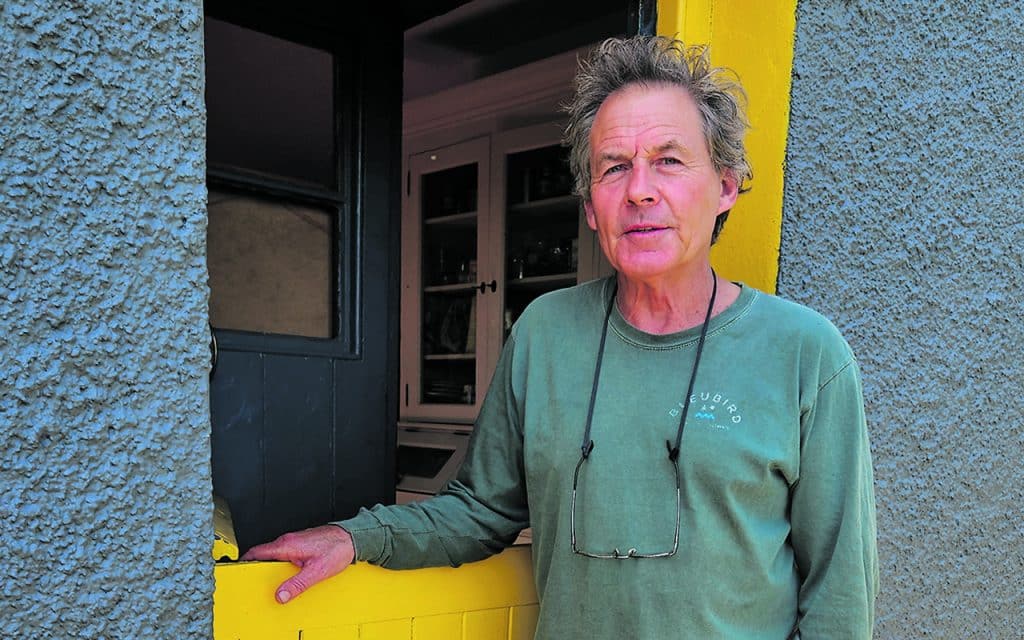 Jerome Lordan standing at his cottage door